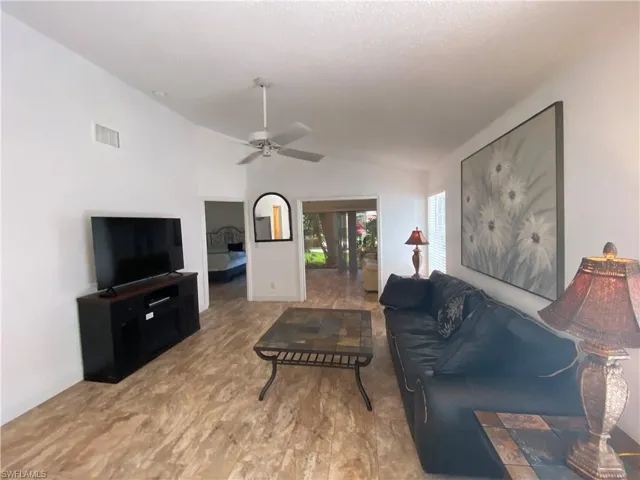 Living room featuring lofted ceiling and a ceiling fan