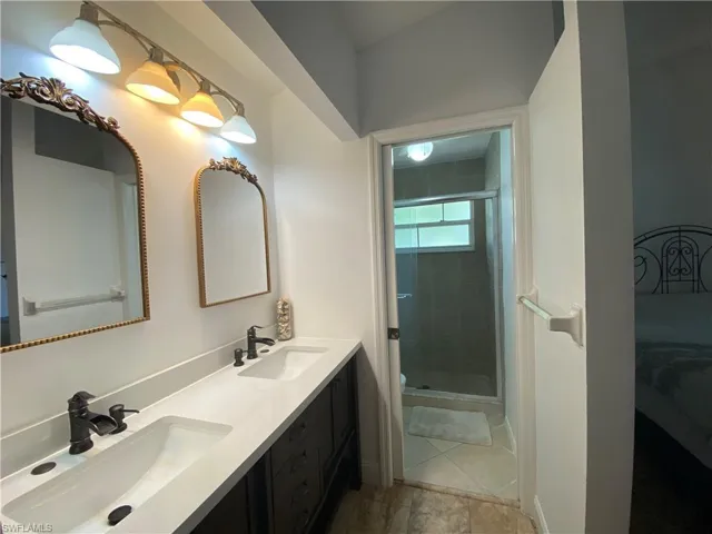 Bathroom featuring double vanity and a shower stall