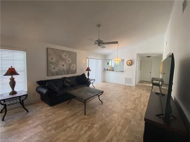 Living room with lofted ceiling and ceiling fan
