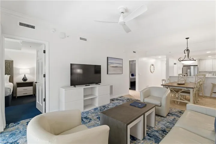 Living room featuring crown molding and ceiling fan