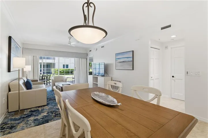 Dining space with light tile patterned floors and crown molding
