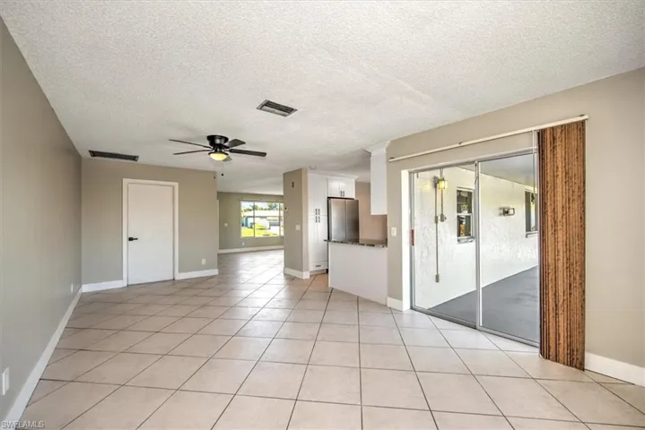 Unfurnished room with light tile patterned floors, a textured ceiling, and ceiling fan