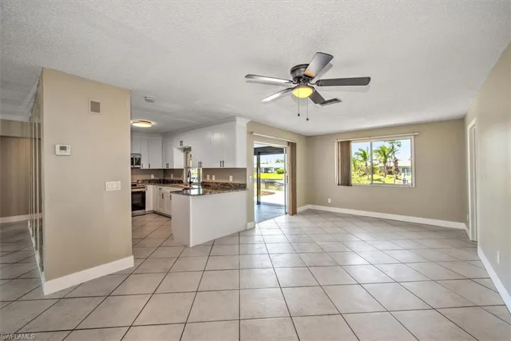 Kitchen with white cabinets, light tile patterned floors, a textured ceiling, and stainless steel appliances