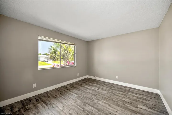 Spare room featuring wood-type flooring and a textured ceiling