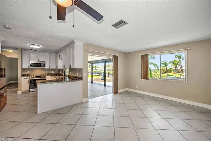 Kitchen featuring white cabinets, stainless steel appliances, kitchen peninsula, and plenty of natural light