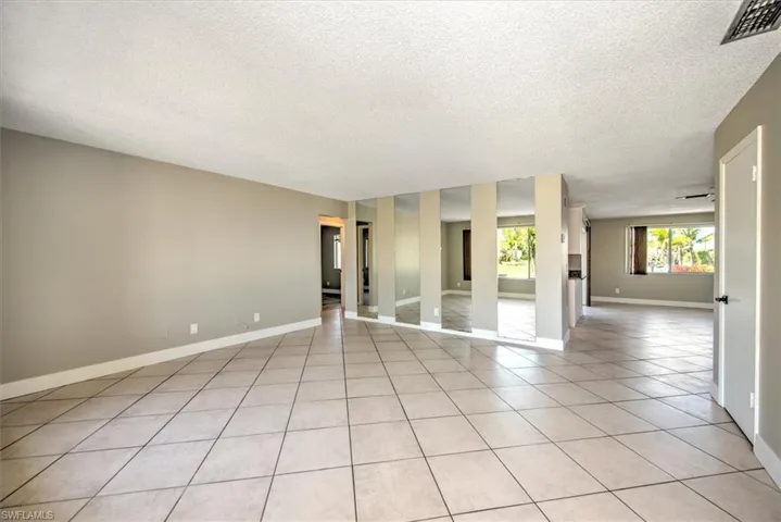 Tiled empty room featuring a textured ceiling