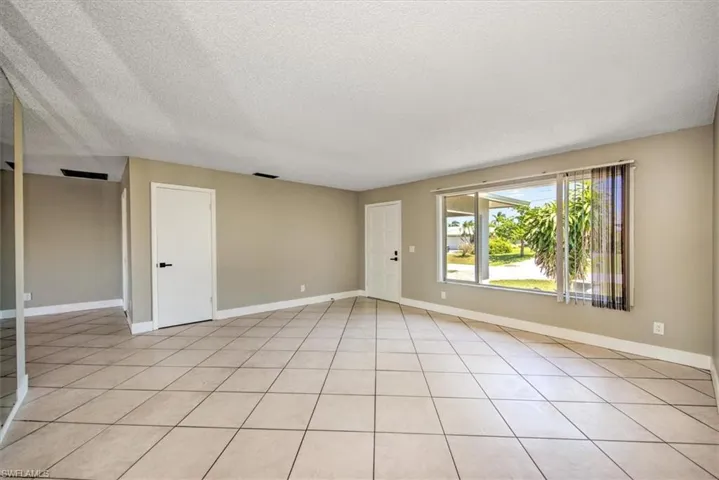 Spare room with a textured ceiling and light tile patterned flooring