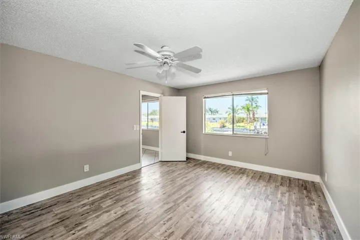 Spare room with ceiling fan, a textured ceiling, and hardwood / wood-style flooring