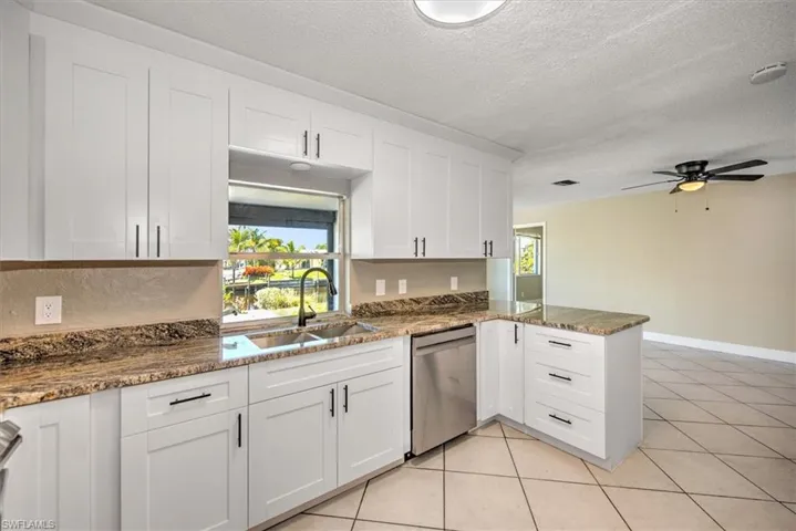 Kitchen featuring white cabinets, dishwasher, and kitchen peninsula