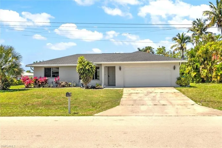 Ranch-style home featuring a front yard and a garage