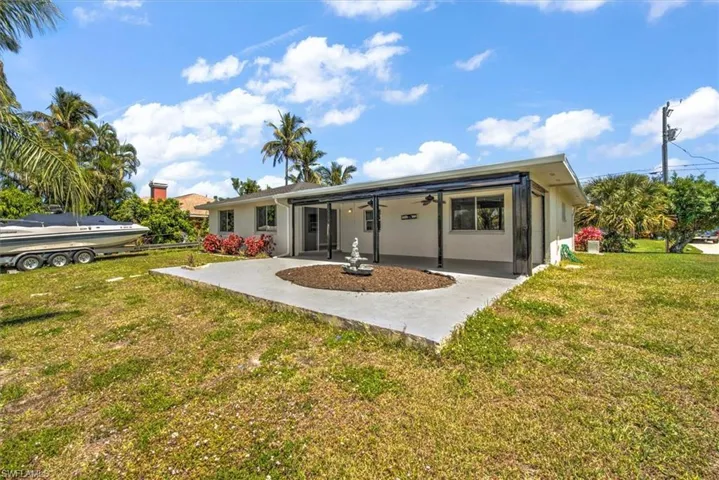 Back of property with a lawn and a patio area