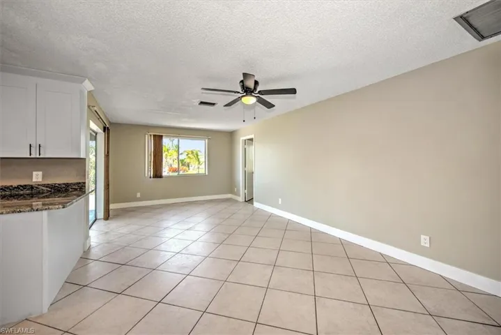 Kitchen with white cabinetry, ceiling fan, and a textured ceiling