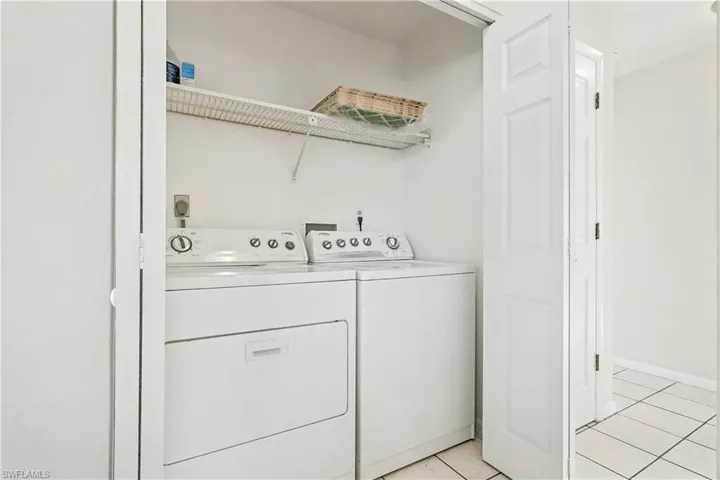 Laundry room featuring separate washer and dryer and light tile patterned floors