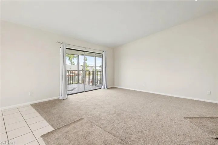 Spare room featuring light carpet and light tile patterned flooring