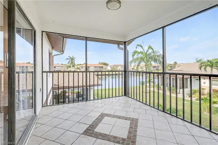 Unfurnished sunroom with a water view, tile patterned flooring, inlaid floor details, and plenty of natural light