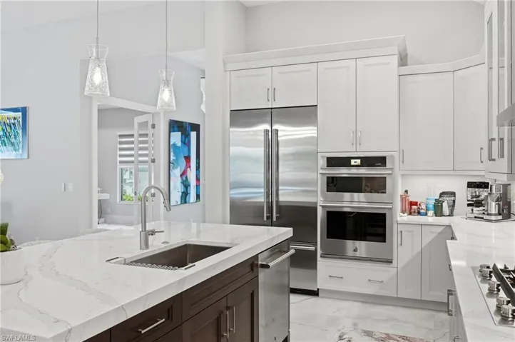 Chef inspired kitchen featuring quartz countertops, gas cooktop, wall oven and oversized island with seating.