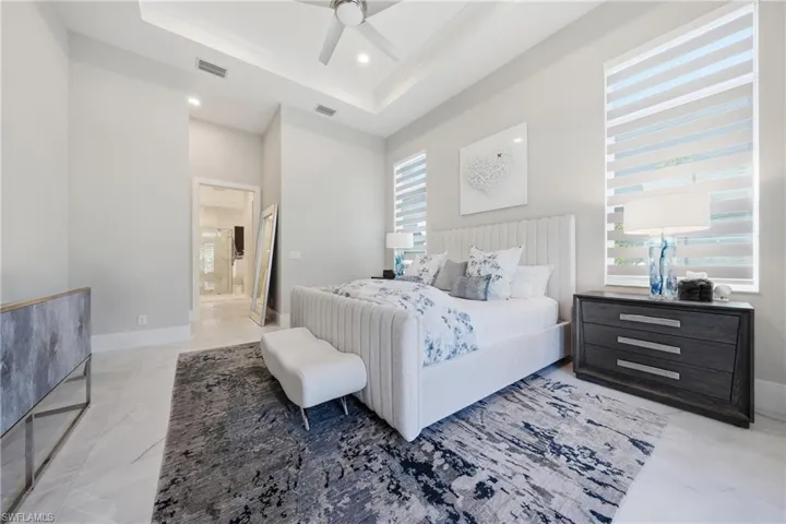 Spacious primary suite with tray ceiling detail and serene preserve views, offering a peaceful retreat with abundant natural light