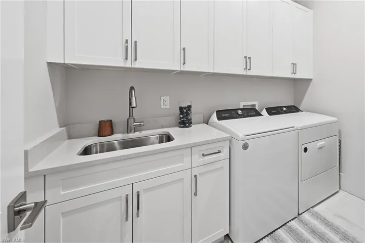 Dedicated laundry room with built in cabinetry and functional workspace.
