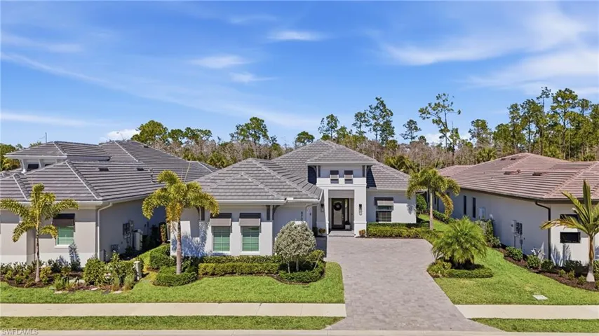 Refined coastal elevation with manicured landscaping and oversized three car garage.