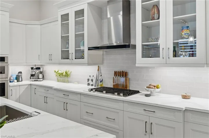 Bright white cabinetry paired with sleek quartz surfaces and stainless appliances create a timeless, modern feel.