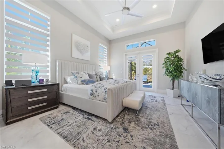 Light filled owner’s suite featuring expansive windows, soft neutral tones and seamless flow into a spa inspired bath.