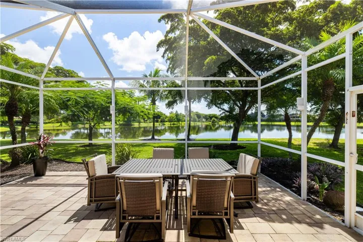 Spacious outdoor lanai with pavers surrounding by mature trees and a gorgeous lake view.