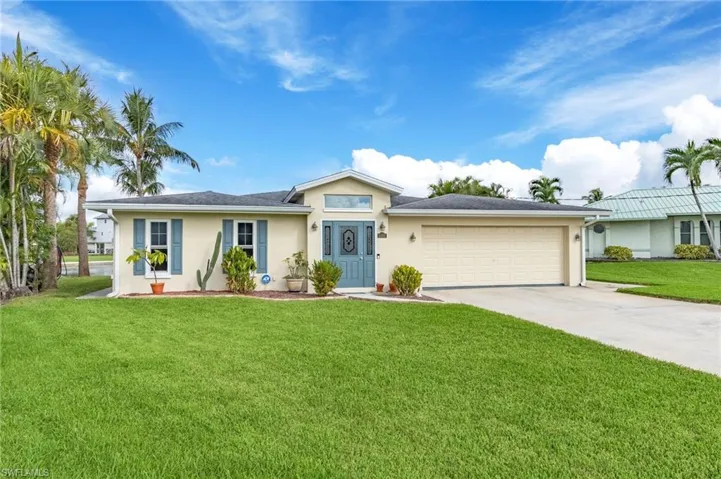Single story home with a garage and a front lawn