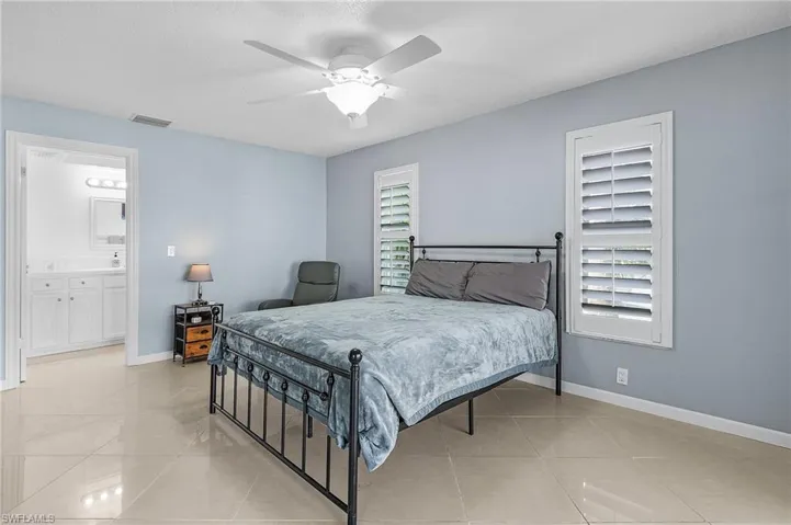 Bedroom featuring connected bathroom and ceiling fan