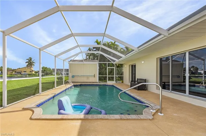 View of pool with a lanai, a patio area, and a yard