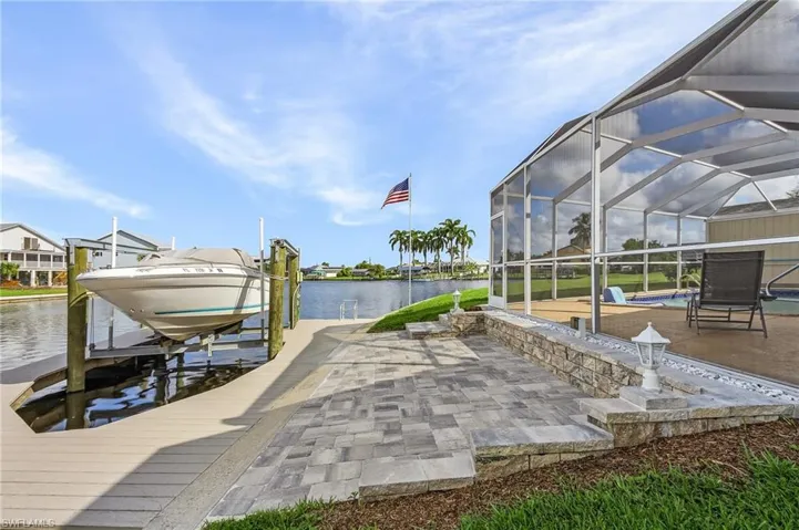 View of dock with a lanai and a water view