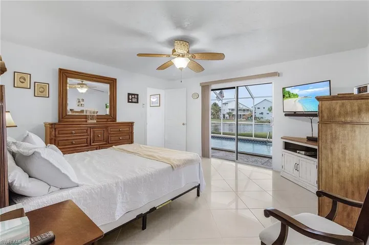 Tiled bedroom featuring ceiling fan and access to outside