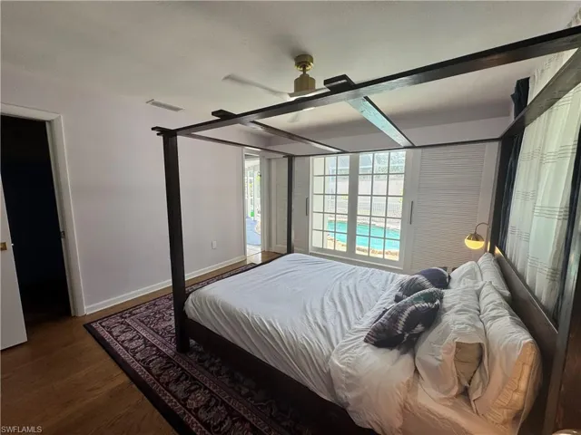 Bedroom with visible vents, wood finished floors, baseboards, and a ceiling fan