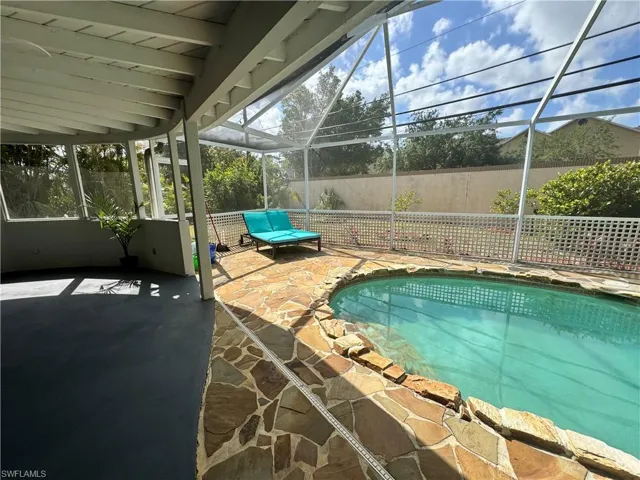 View of pool with fence, a patio area, glass enclosure, and a fenced in pool