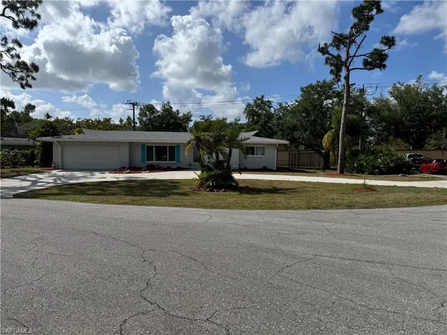 Ranch-style home with stucco siding, an attached garage, a front yard, and concrete driveway