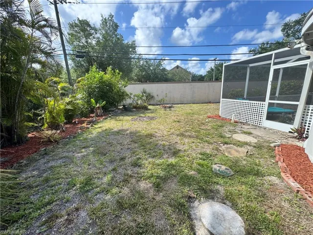 View of yard featuring fence and glass enclosure