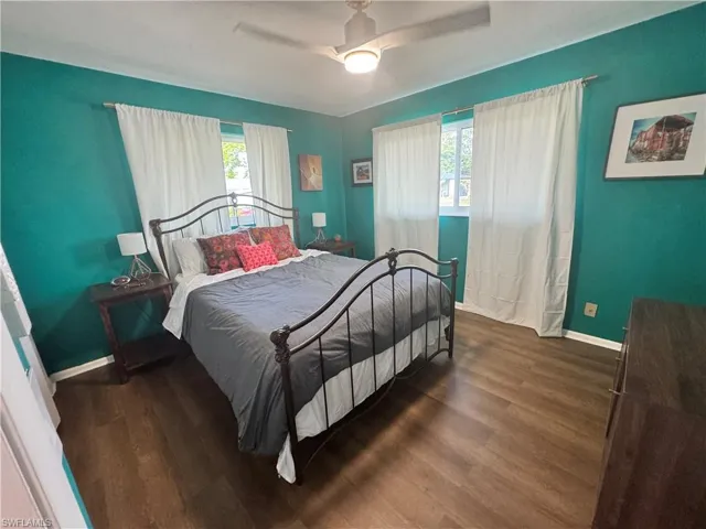 Bedroom featuring ceiling fan, baseboards, and wood finished floors