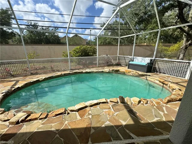 View of pool featuring fence, a patio area, a fenced in pool, and glass enclosure