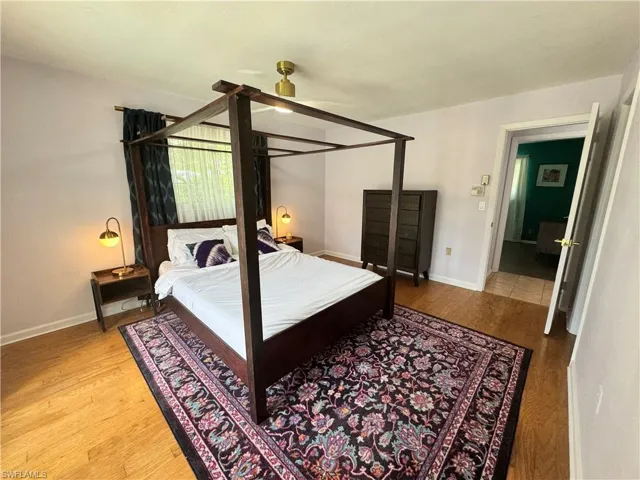 Bedroom with wood finished floors and baseboards