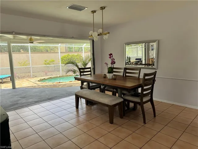 Dining room featuring light tile patterned flooring and visible vents