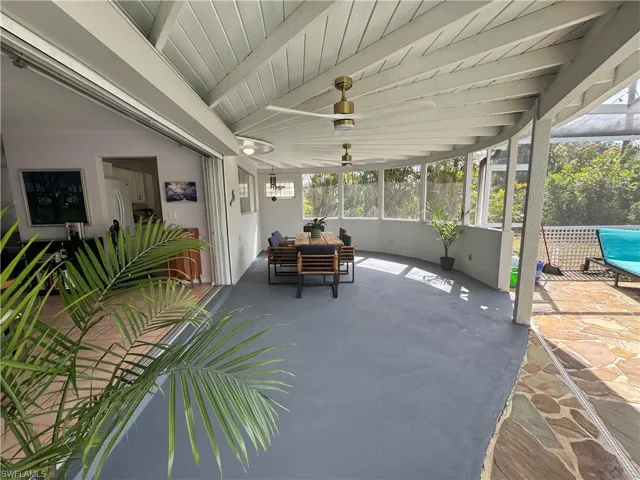 Sunroom / solarium with beam ceiling and ceiling fan