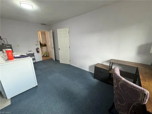 Office featuring washer / dryer and dark carpet