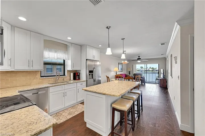 Kitchen with stainless steel appliances, a sink, crown molding, a kitchen island, and tasteful backsplash