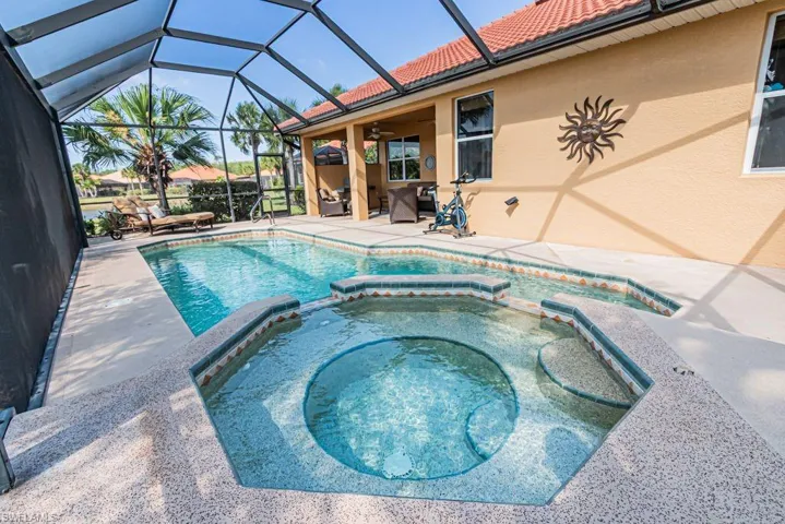 View of swimming pool with a lanai, a patio, a pool with connected hot tub, and a ceiling fan