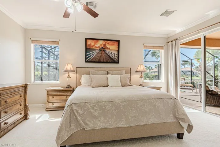 Bedroom featuring access to outside, light colored carpet, crown molding, and visible vents
