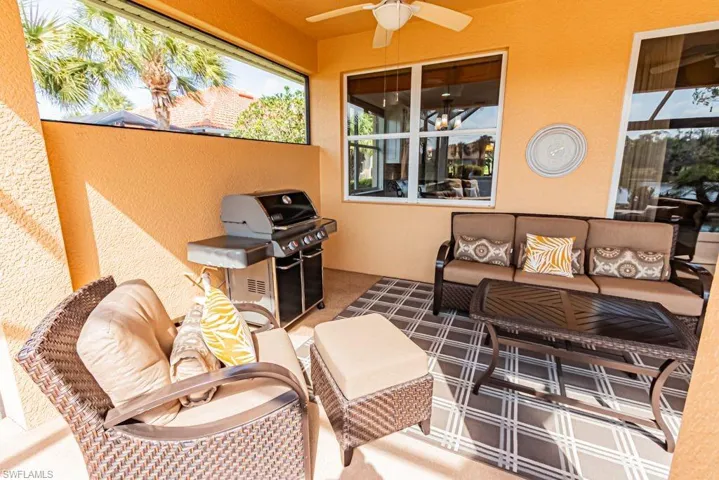 View of patio featuring grilling area, an outdoor hangout area, a ceiling fan, and a balcony