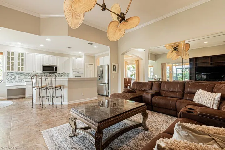 Living area with crown molding, recessed lighting, and arched walkways