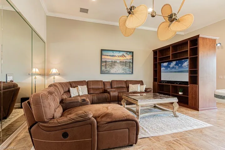 Living area with crown molding and visible vents