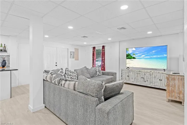 Living room with light wood-style floors, recessed lighting, and a drop ceiling