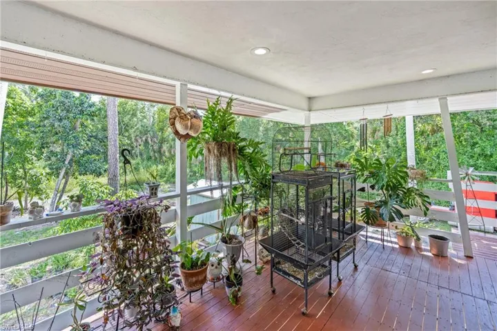 Sunroom featuring hardwood / wood-style floors, recessed lighting, and a wall of windows