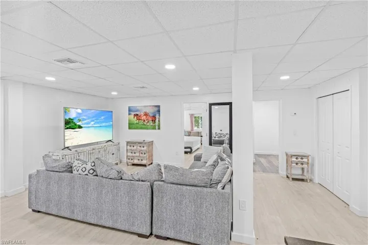 Living area with recessed lighting, light wood-type flooring, and a paneled ceiling
